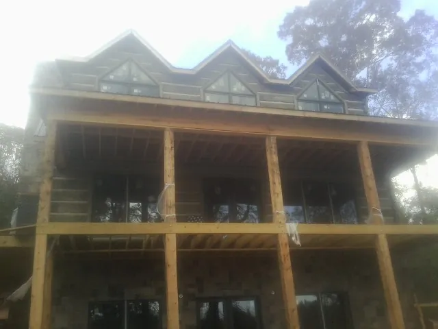 Dormers and porch framing on a large log home under construction — Roof Coating work by our crew in Klickitat