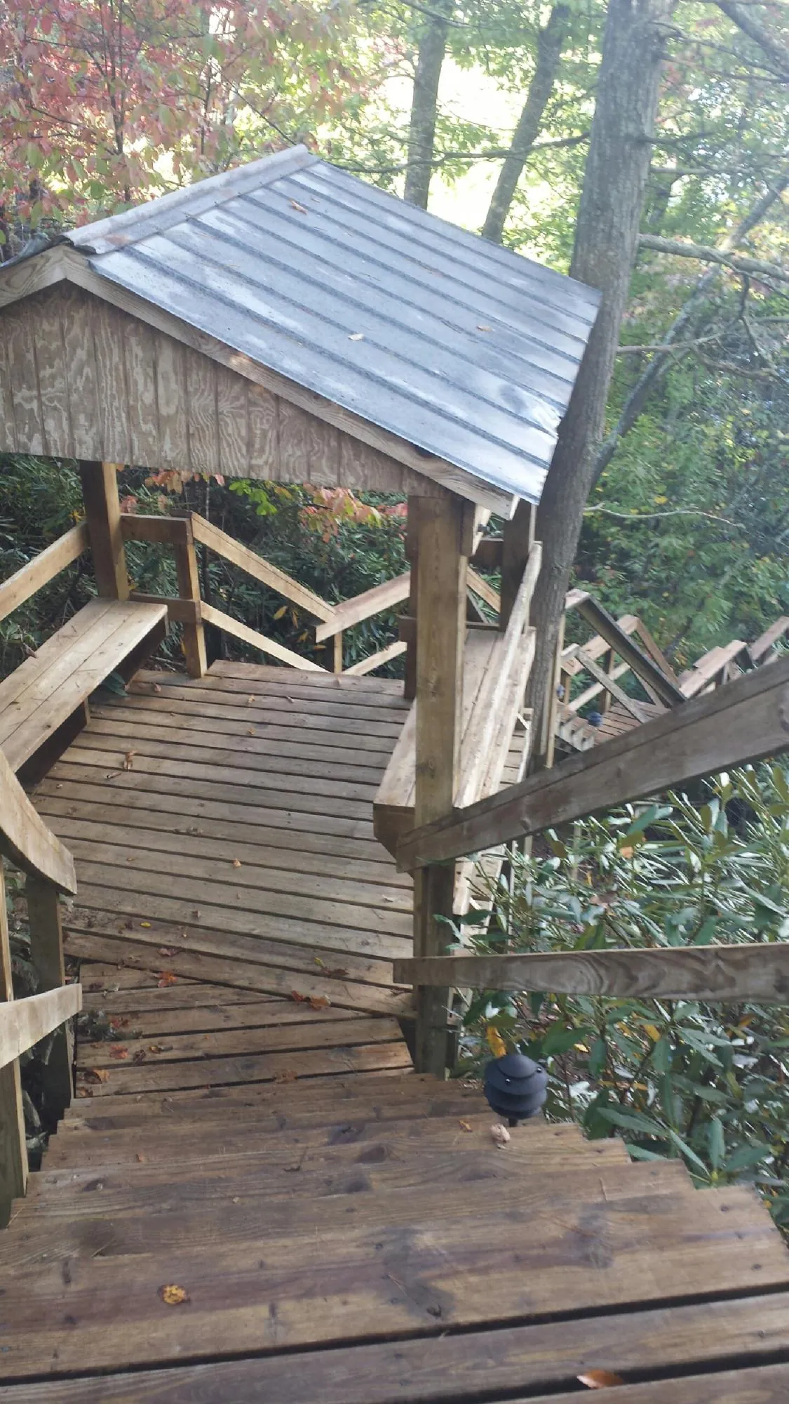 Metal roofed shelter over wooden steps on a wooded walkway — Skylight Repair & Installation work by our crew in Klickitat